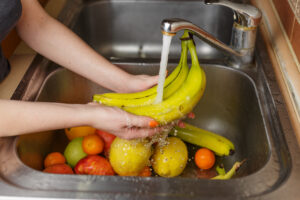 Happy Woman Washing Fruit Kitchen Bananas Tangerines Apples