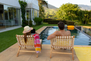 Happy Young Couple Relaxing Near Swimming Pool