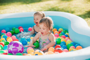 Two Little Baby Girls Playing With Toys Inflatable Pool Summer Sunny Day