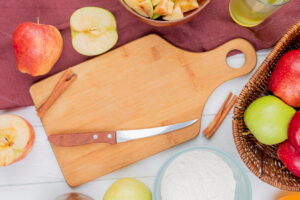 Top View Cinnamon Knife Cutting Board With Apples Flour Apple Juice Bordo Cloth Wooden Background