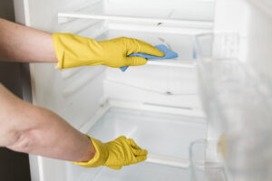 Woman Cleaning Inside Fridge