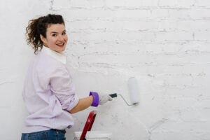 Woman Painting Wall Looking Camera