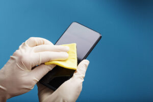 Cleaning Mobile Phone Screen With Yellow Cloth Rubber Gloves