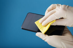 Cleaning Smartphone With Sterile Yellow Napkin Rubber Gloves Blue Surface