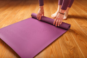 woman lays out lilac yoga mat wooden floor women practicing yoga healthy lifestyle isolation 1