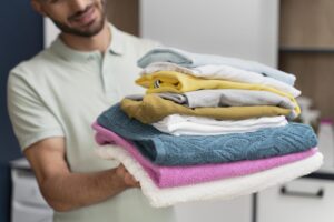 Man Holding Pile Clean Clothes