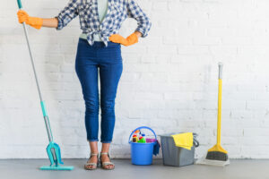 Woman Standing Front Brick Wall With Cleaning Equipments