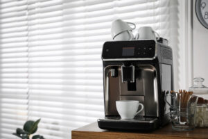 Modern Coffee Machine With Cup Office Space Text