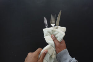 Person Hand Cleaning Drying Cutlery With Towel 1