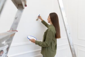 Woman Painting Wall Medium Shot